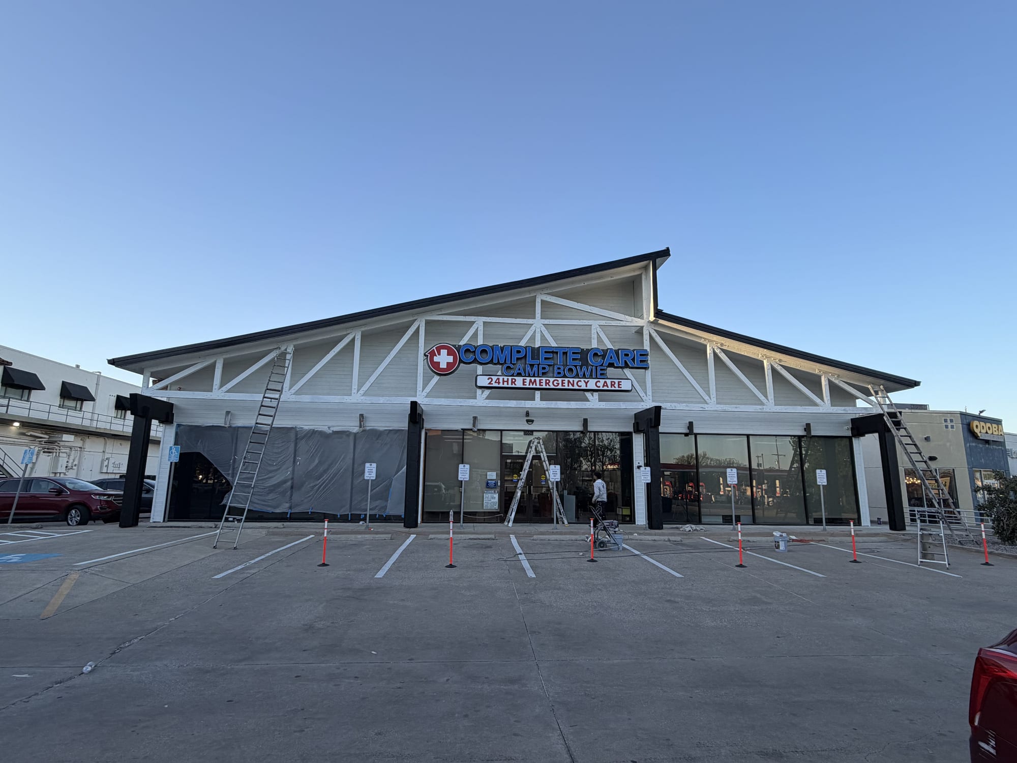 Same commercial building repainted white with clean storefront trim, Spartan Painting