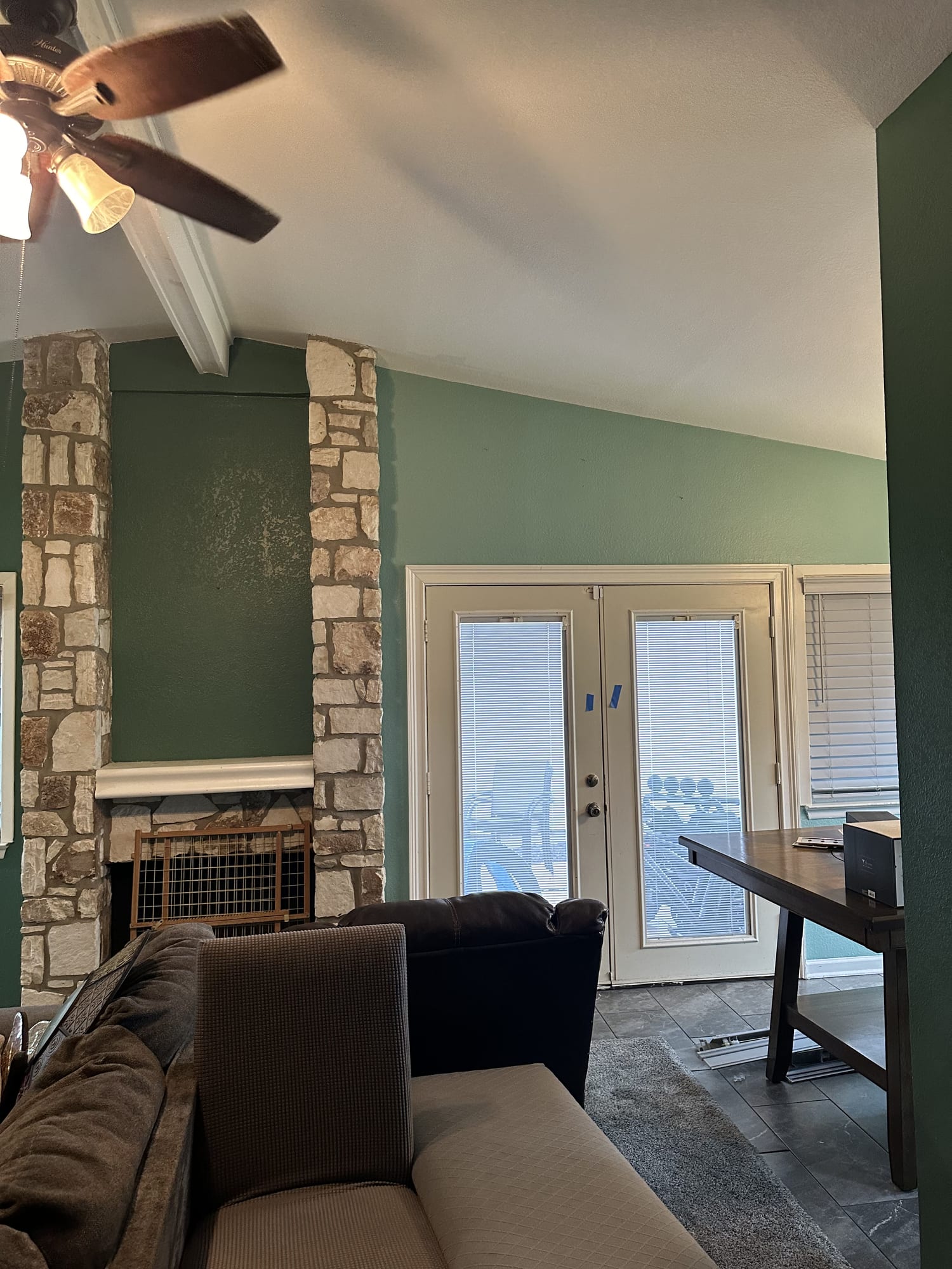 Same living room and stone fireplace repainted sage green
