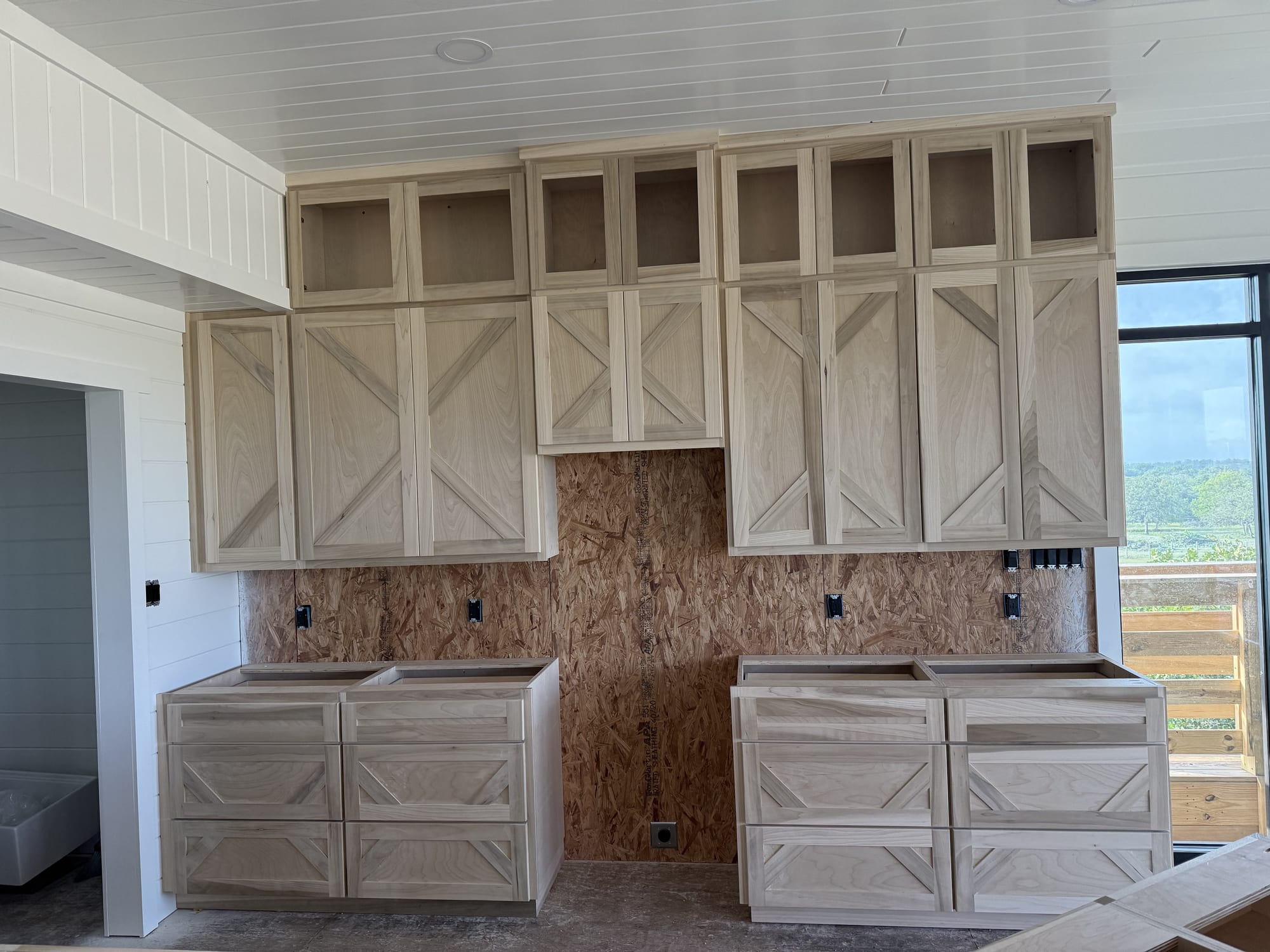 Unfinished kitchen cabinets awaiting priming and a sprayed finish