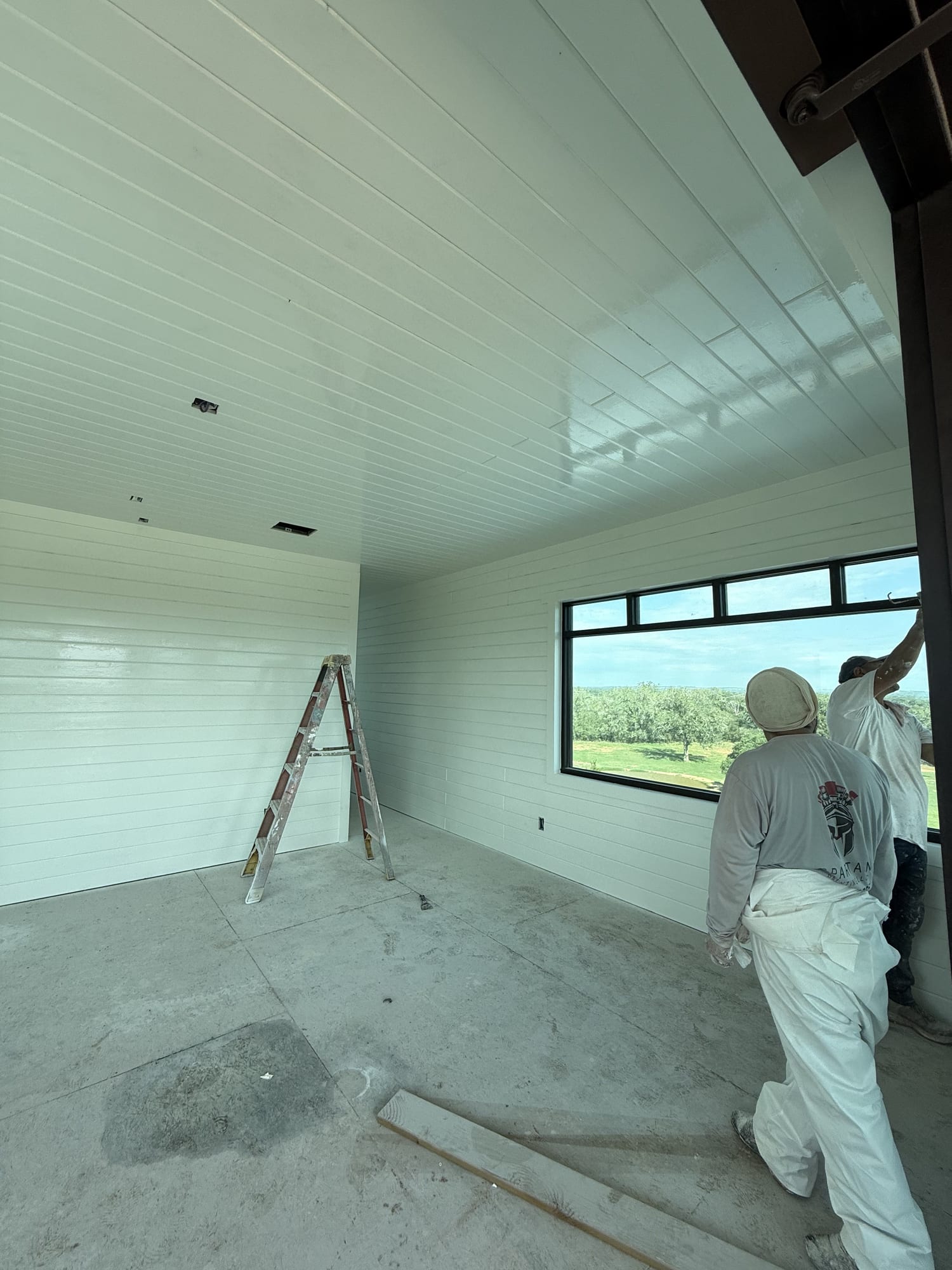 Crew painting a patched and repaired interior wall