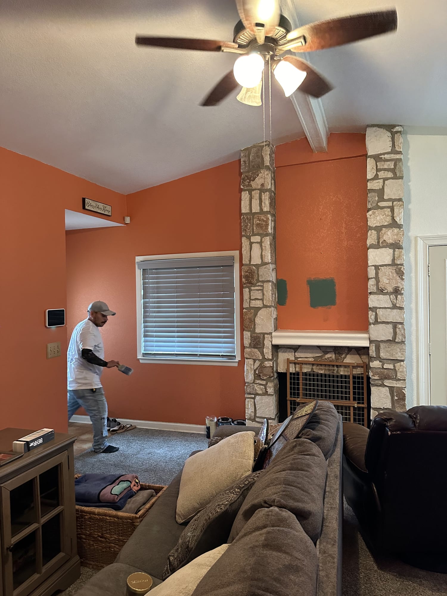 Painter cutting in a new wall color over a dated orange living room